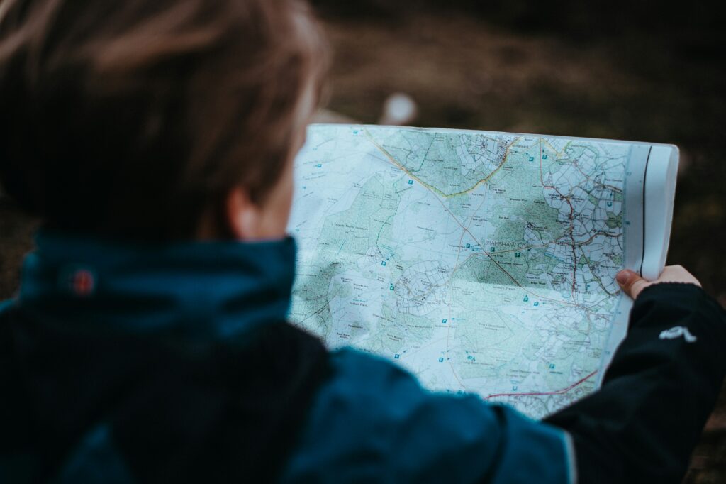 A view looking over a woman's shoulder while she's holding a paper map of of Bramshaw, UK.